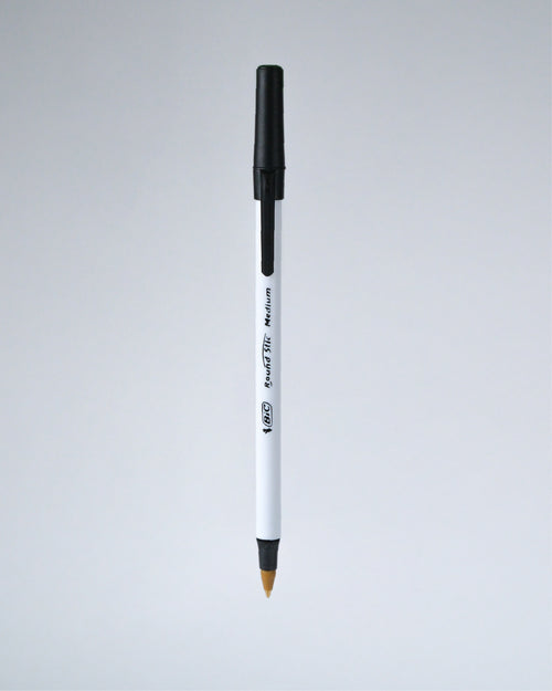 A single white and black ballpoint pen with a gold-tipped tip, shown vertically against a light gray gradient background.