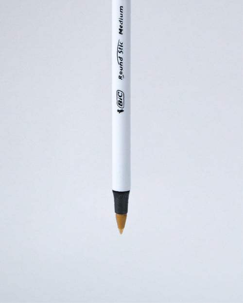 A single BIC Round Tip Medium pencil shown vertically against a light gray background.