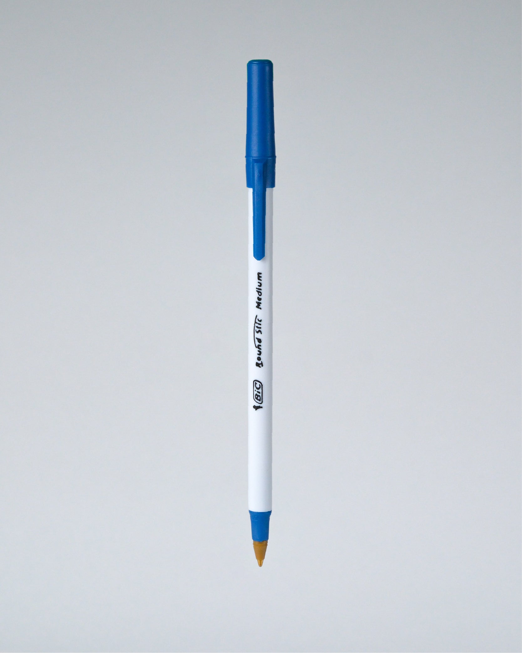 A blue and white Perfora ballpoint pen with a gold tip, shown vertically against a neutral gray gradient background.