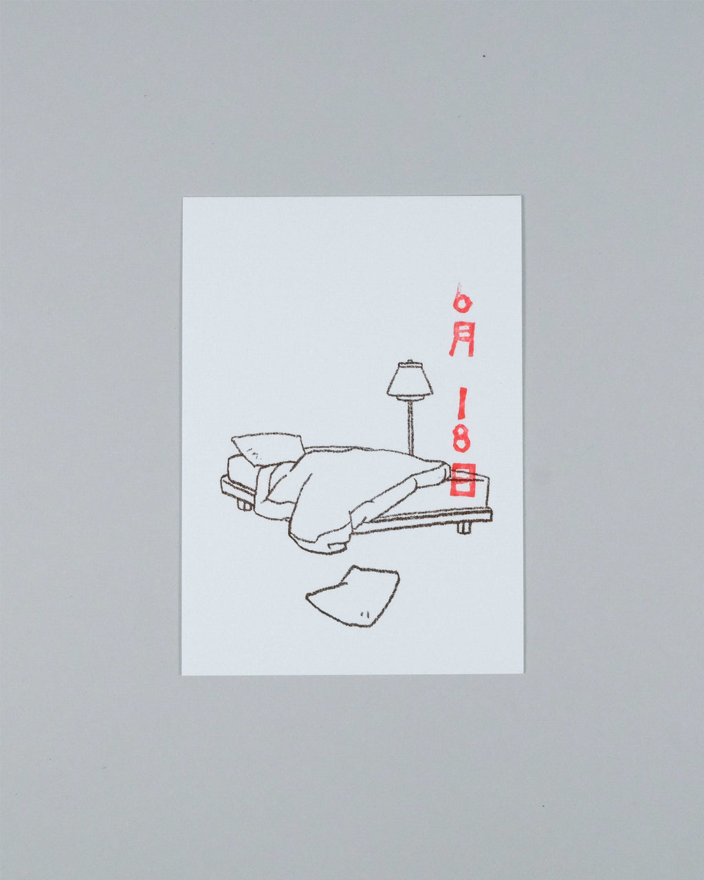 A minimalist art print featuring a black line drawing of a bed with a lamp and a broken piece of paper, with the date '6月18日' written in red on the right, displayed on a neutral gray background.