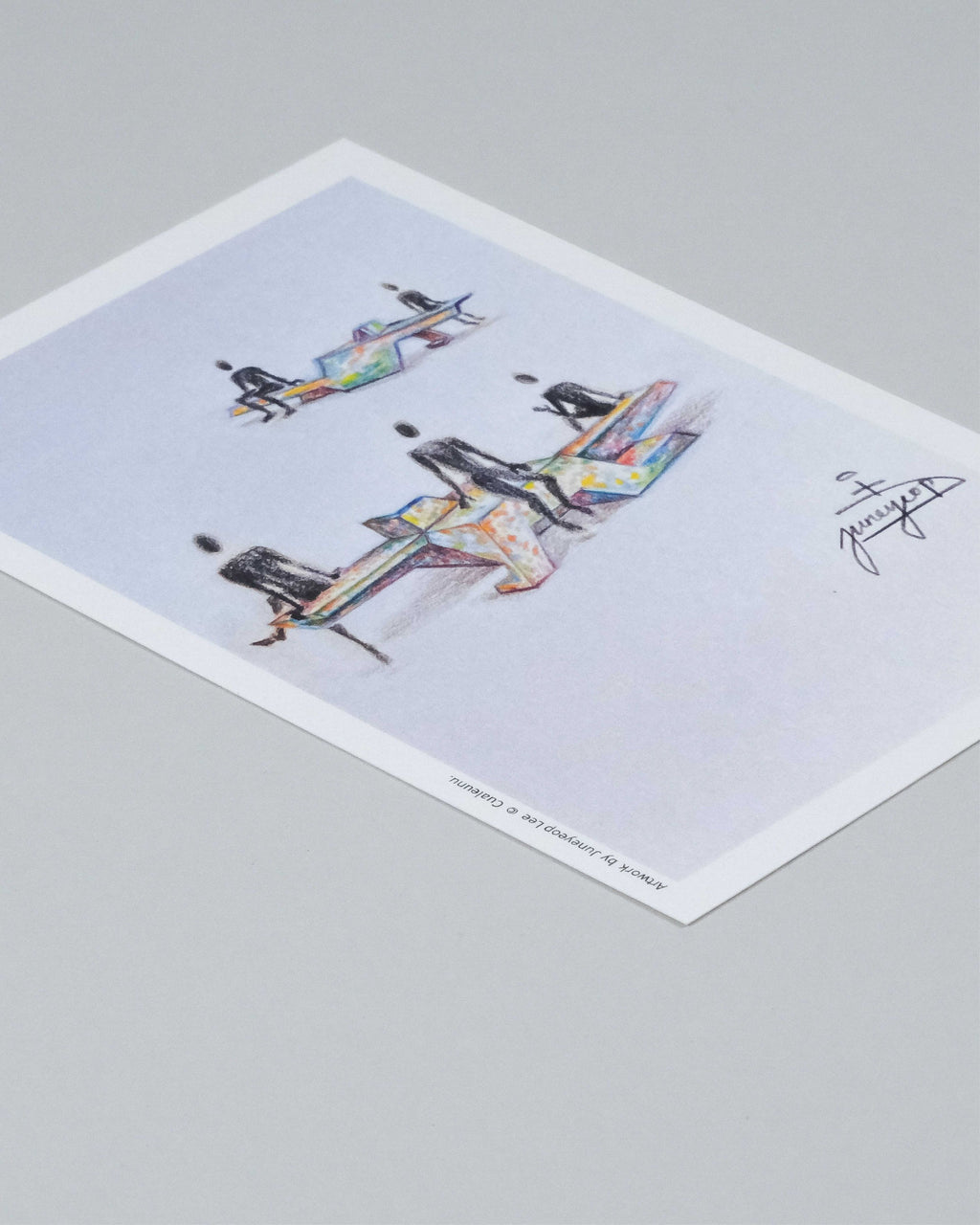 A printed art card or poster featuring a colorful watercolor-style illustration of three futuristic spacecraft on a pale background, photographed at an angle on a light gray surface.