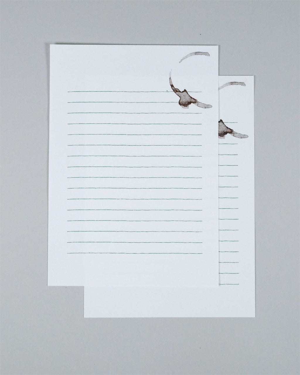 Two overlapping lined writing paper sheets on a light gray background, each printed with a small bird illustration near the top right.