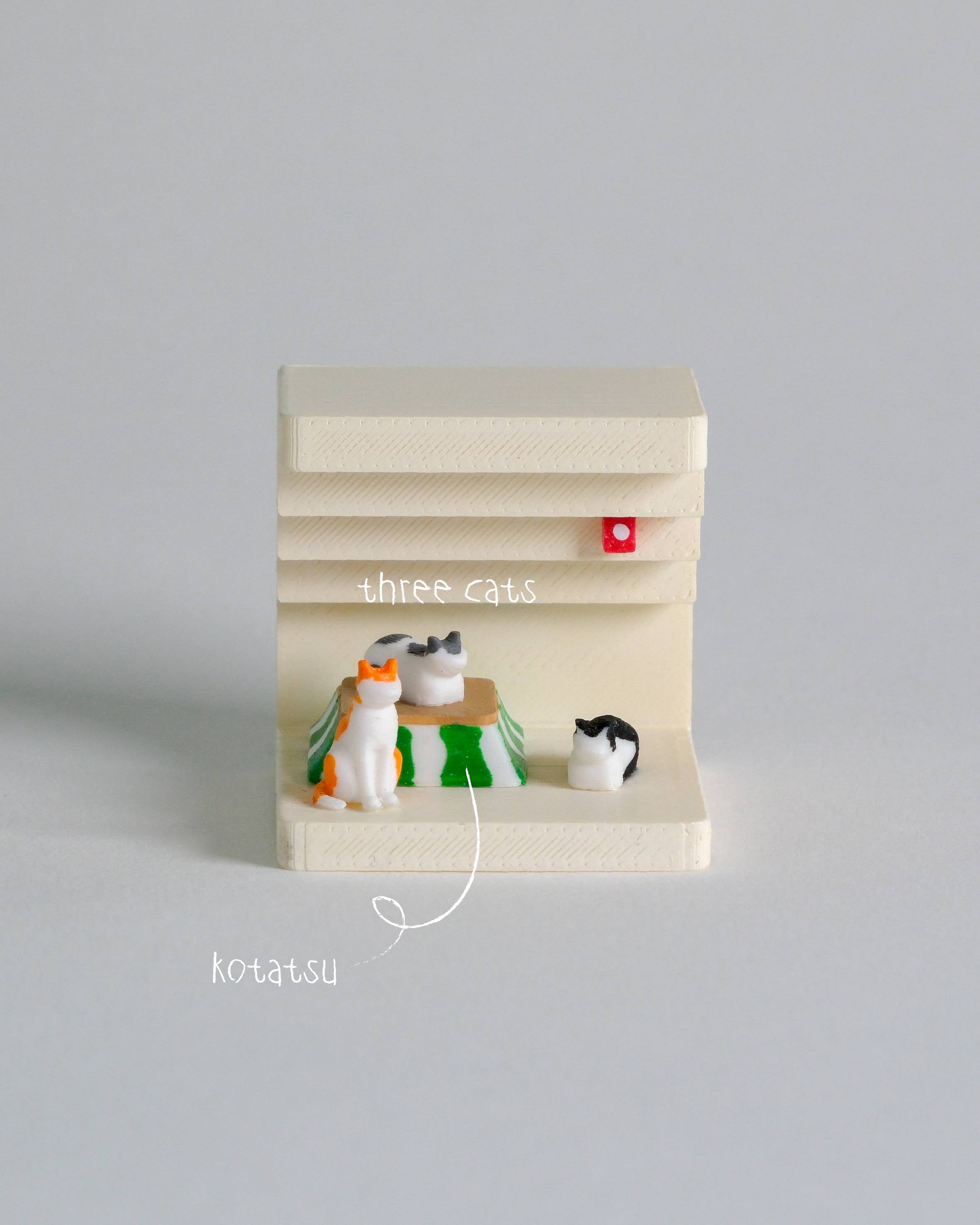 Miniature model of a cat tree with three toy cats on a gray background