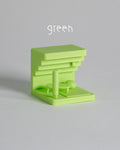 Green plastic component on a gray background with 'green' text above it.
