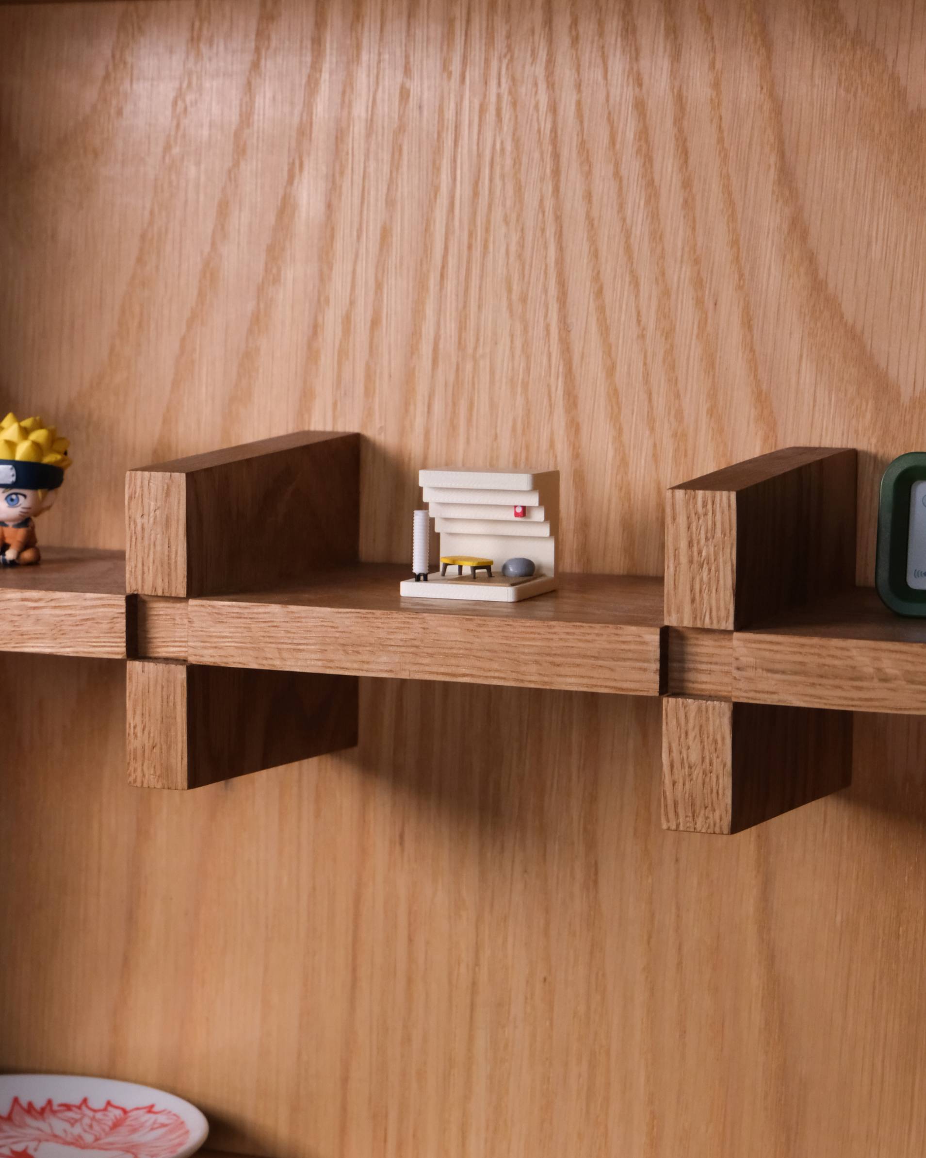 Wooden floating shelf brackets mounted on a wood-grained wall, with small decorative objects placed on the shelves.