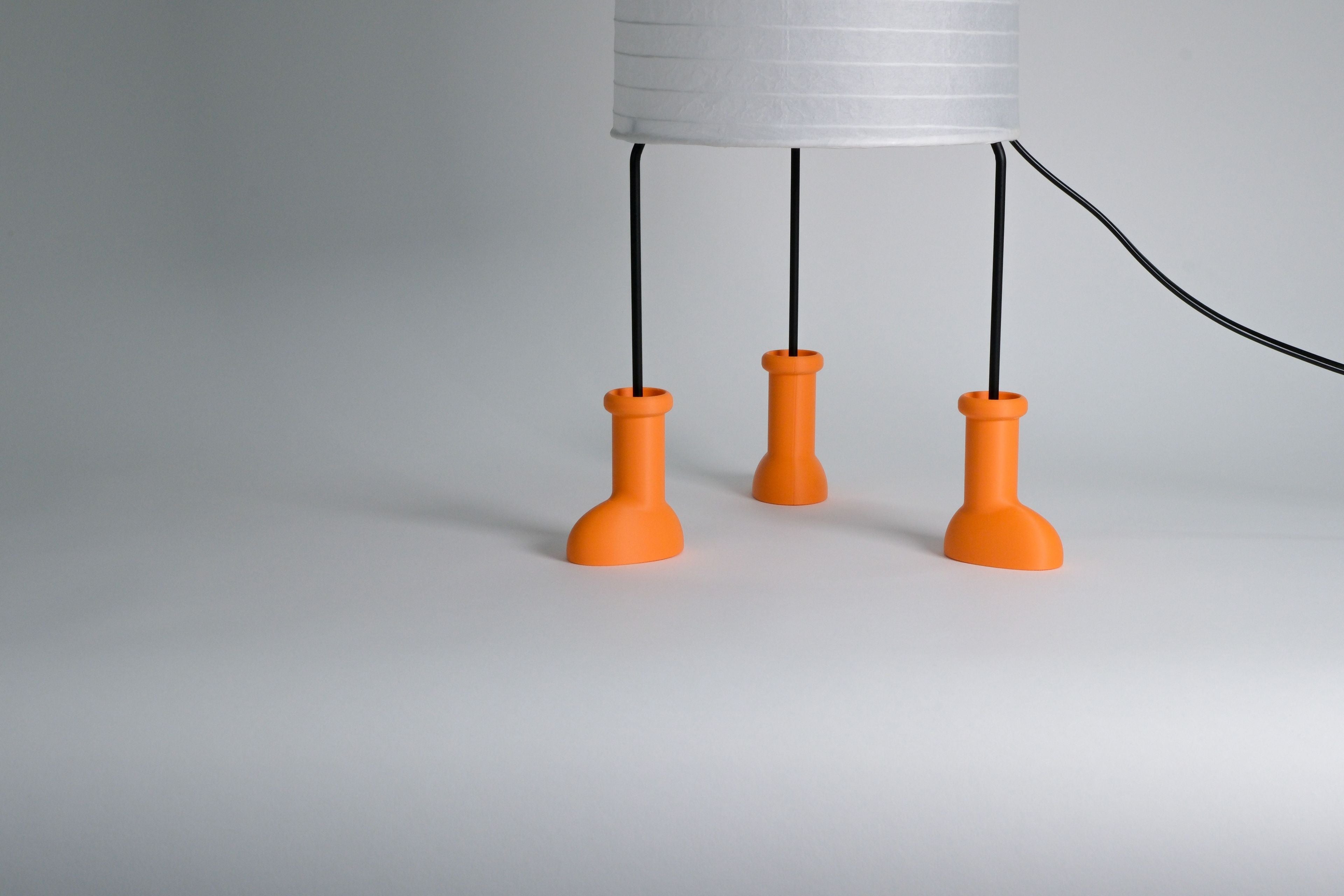 ikea strandad lamp wearing three small orange boot